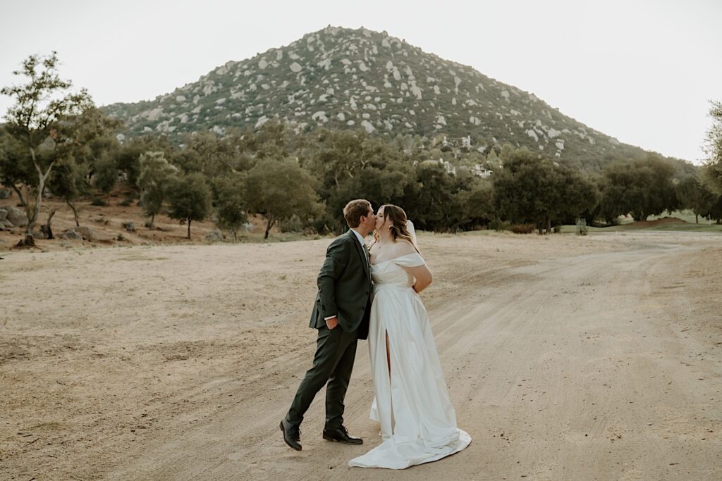 A bride and groom dance together in the California desert during their wedding at Mt Woodson Castle