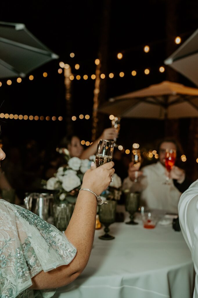 The mother of the bride shares a toast with fellow guests during her daughters outdoor wedding reception at Mt Woodson Castle.