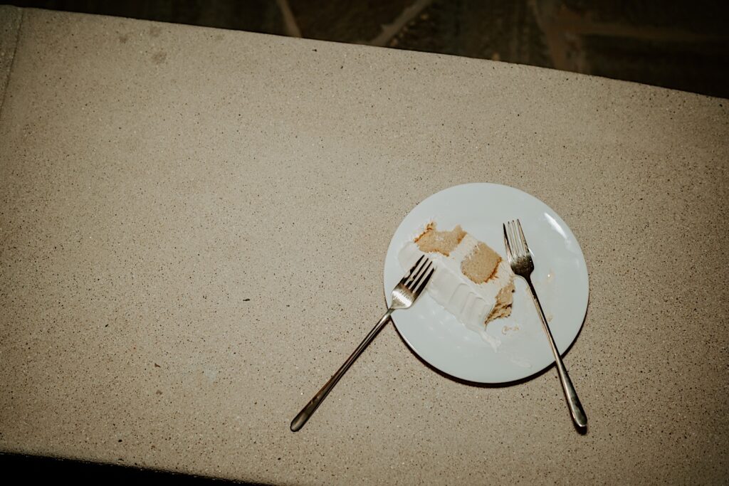 A flash photo of wedding cake with two forks.  