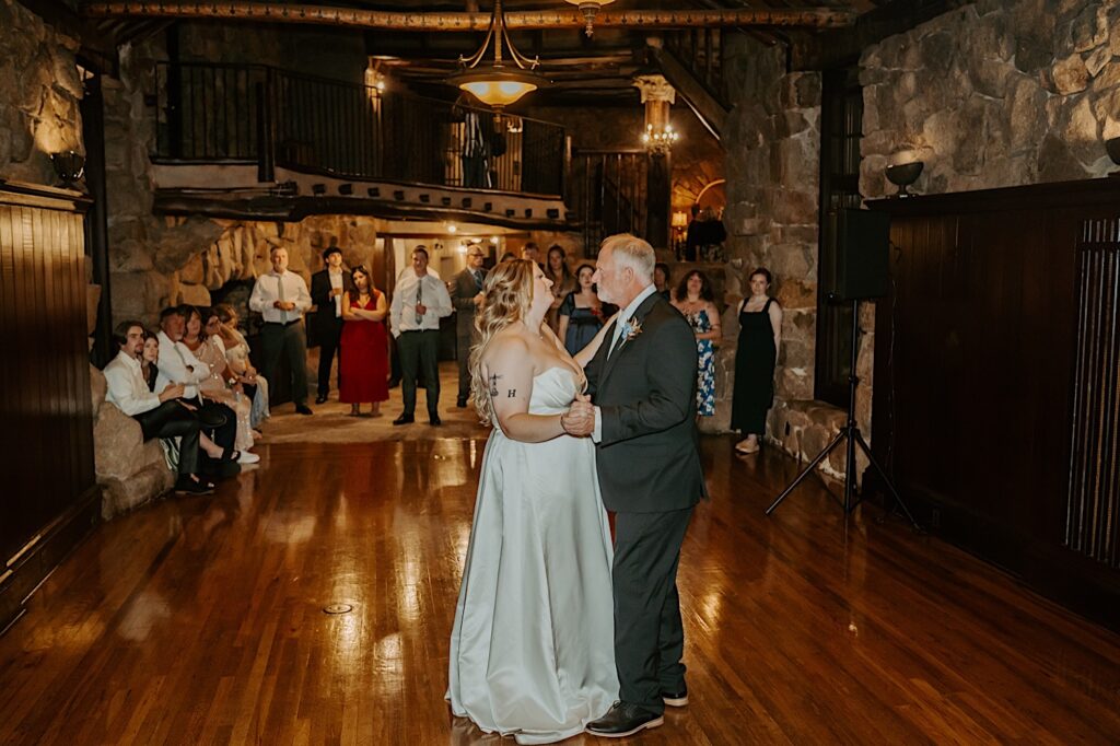 A bride shares a first dance with her father at Mt Woodson Castle in California. 