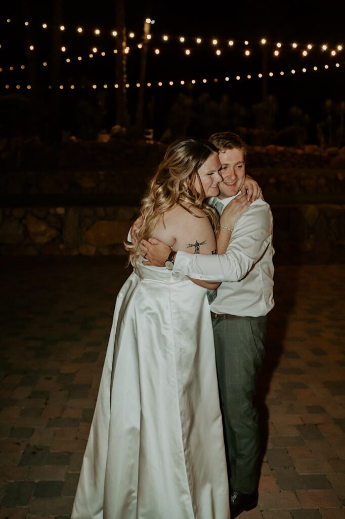 A bride and groom embrace at night celebrating their wedding day at their California wedding venue. 