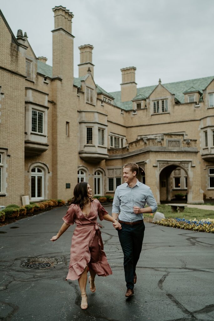 couple running together in spring colors with a castle behind them