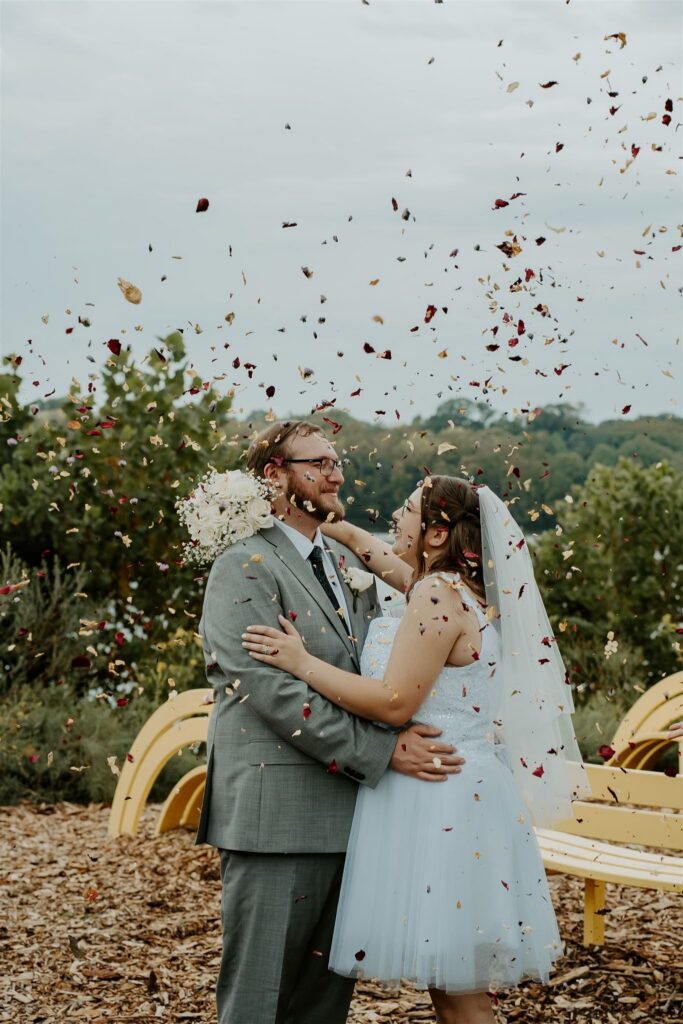 wedding couple hugging together as confetti is thrown onto them