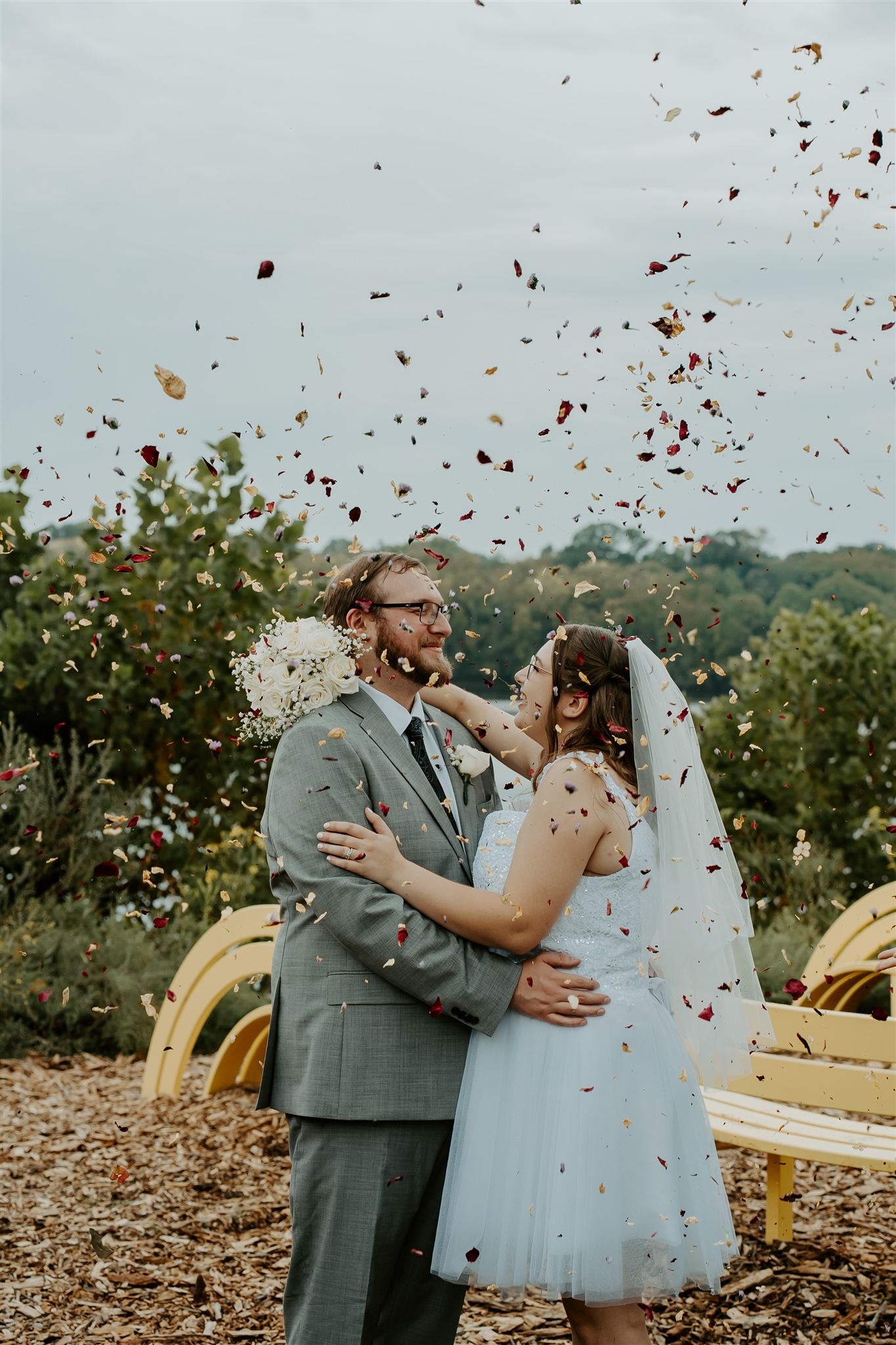 couple hugging outside in the fall with confetti thrown onto them