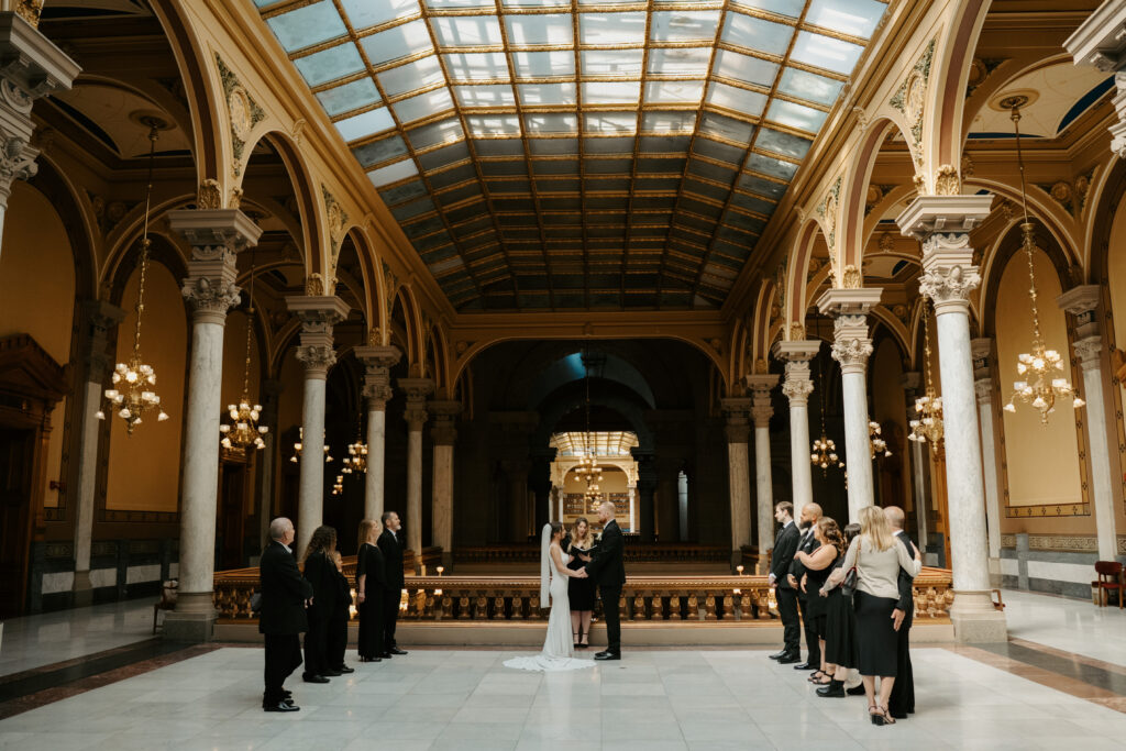bride and groom standing at the center surrounded by family during their ceremony