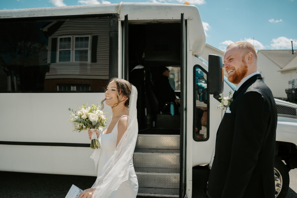 bride and groom talking by a bus