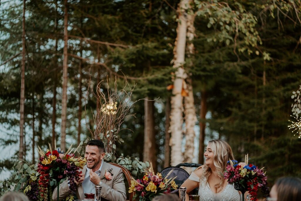 couple smiling while eating dinner at backyard reception