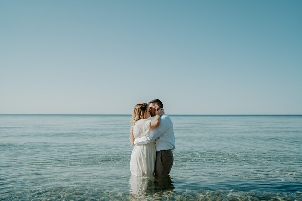 couple kissing while standing in the lake