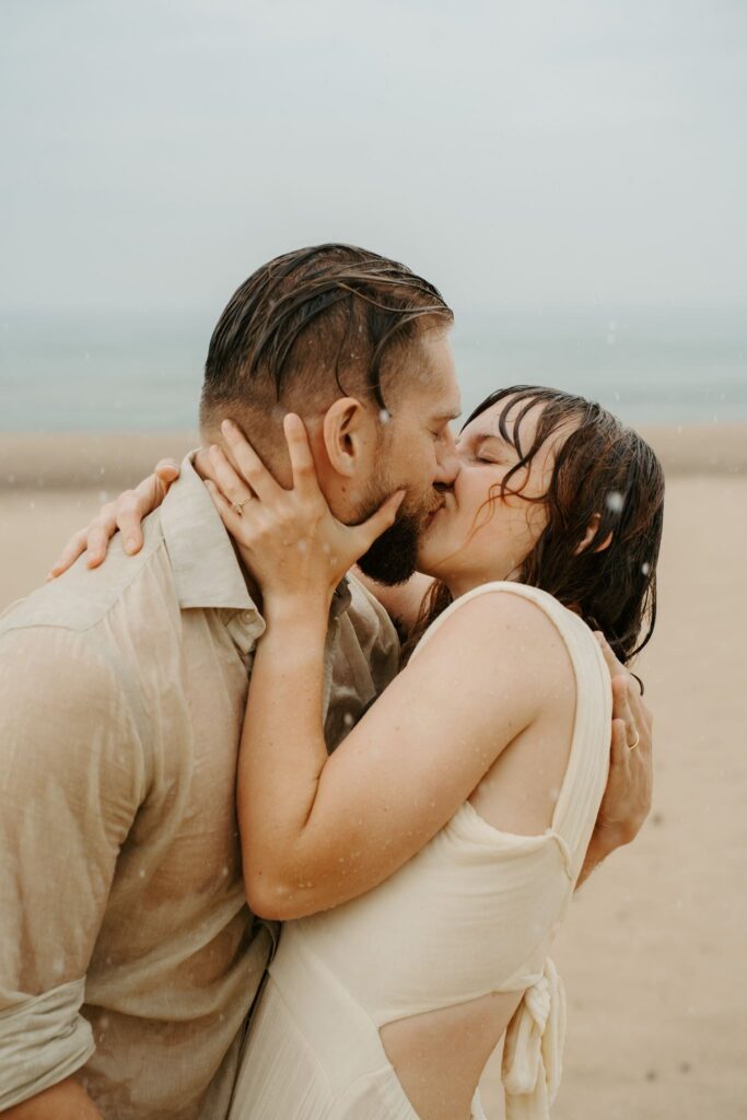 couple kissing in rain on the beach